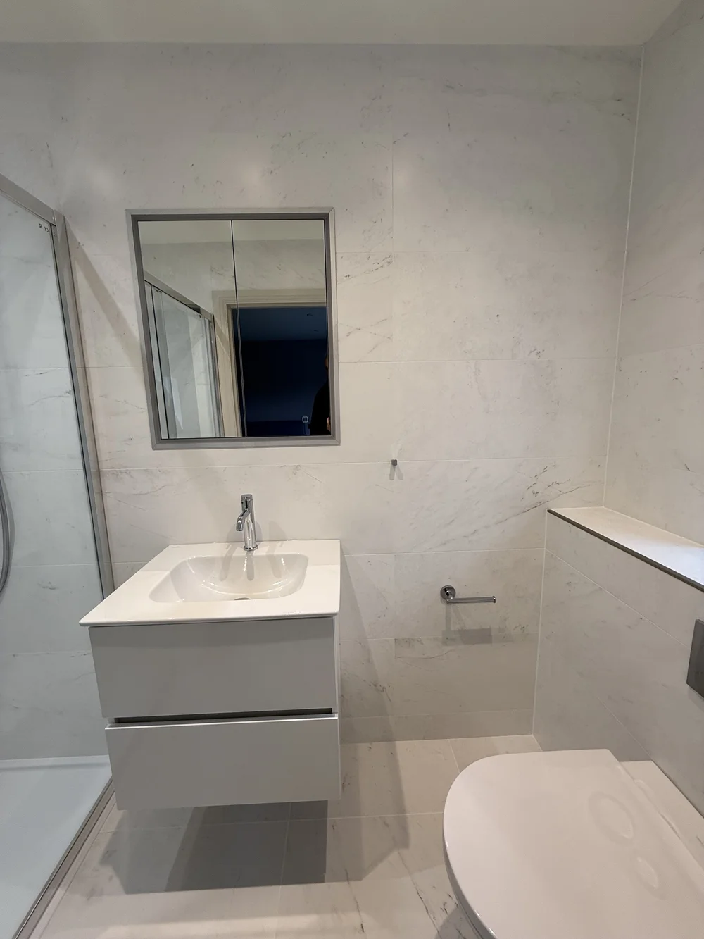 Compact marble ensuite with wall-hung vanity and back-to-wall WC — Basingstoke bathroom fitters