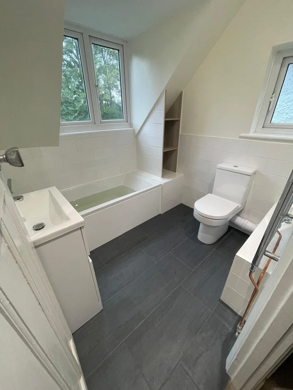 Bright loft family bathroom with metro tiles and slate-tiled floor — bathroom installation Basingstoke