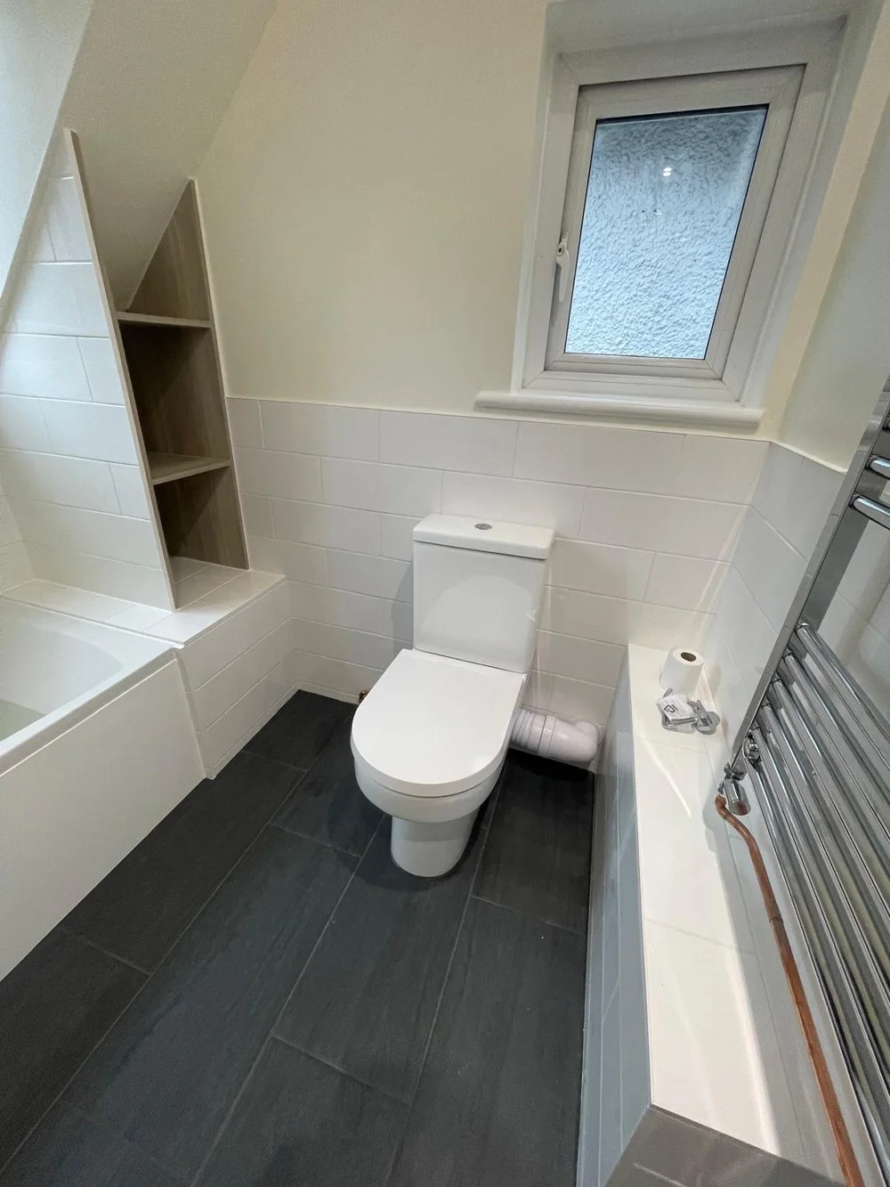 Loft bathroom with metro tiles, bespoke oak shelving and slate floor — bathroom installers Basingstoke