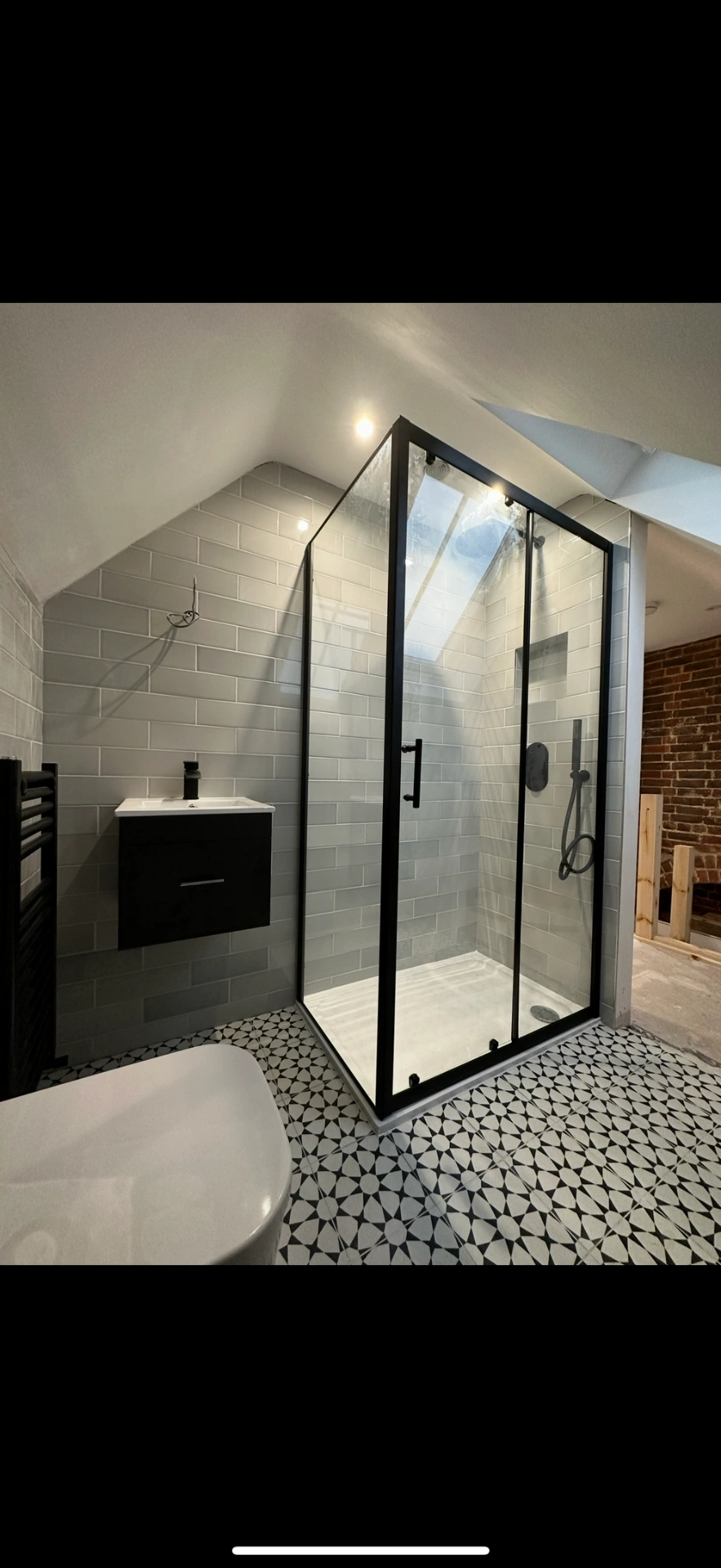 Loft ensuite with matte-black framed shower enclosure and patterned floor — Basingstoke