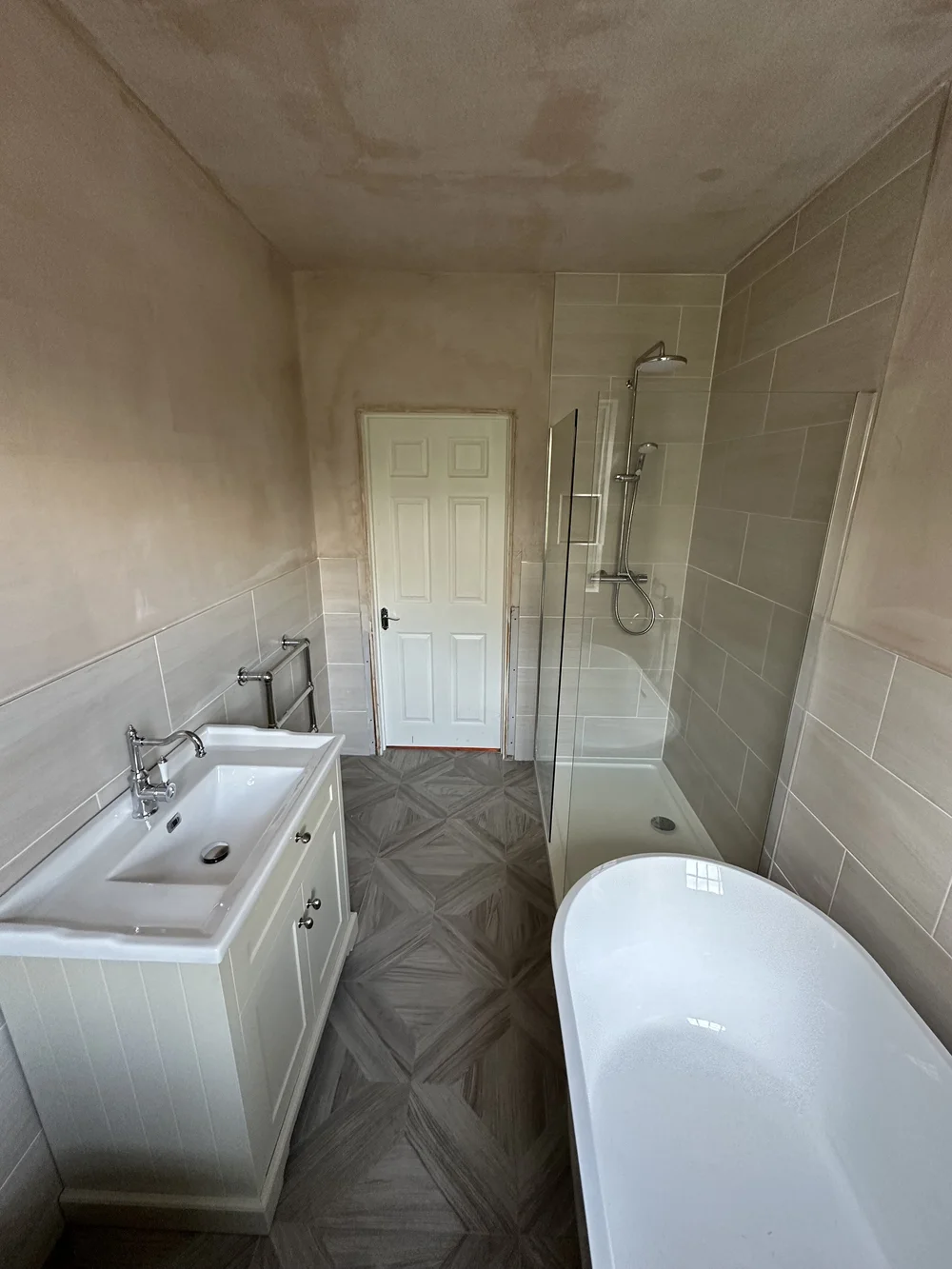 Family bathroom mid-renovation with fresh plaster, shaker vanity, walk-in shower and freestanding bath — bathroom renovation Basingstoke