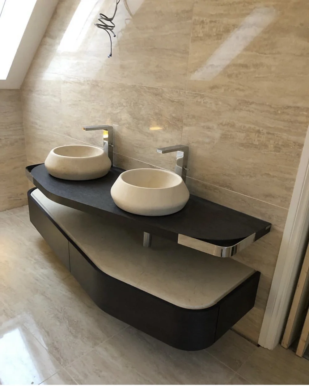 Bespoke twin stone vessel basins on curved slate vanity in travertine ensuite — bathroom design Basingstoke