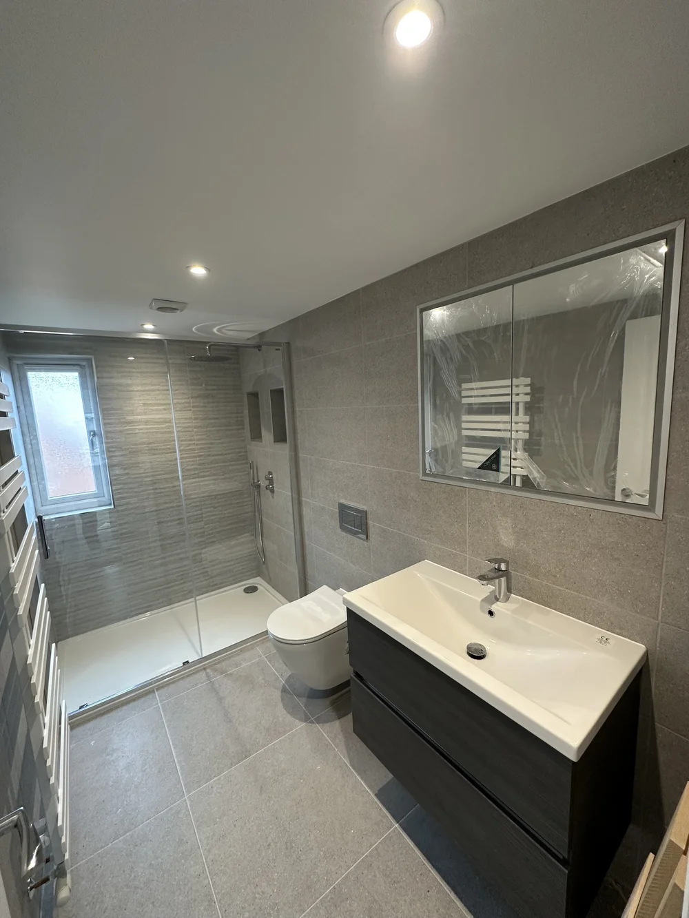 Contemporary shower room with graphite vanity, walk-in shower and mirrored cabinet — bathroom renovation Basingstoke