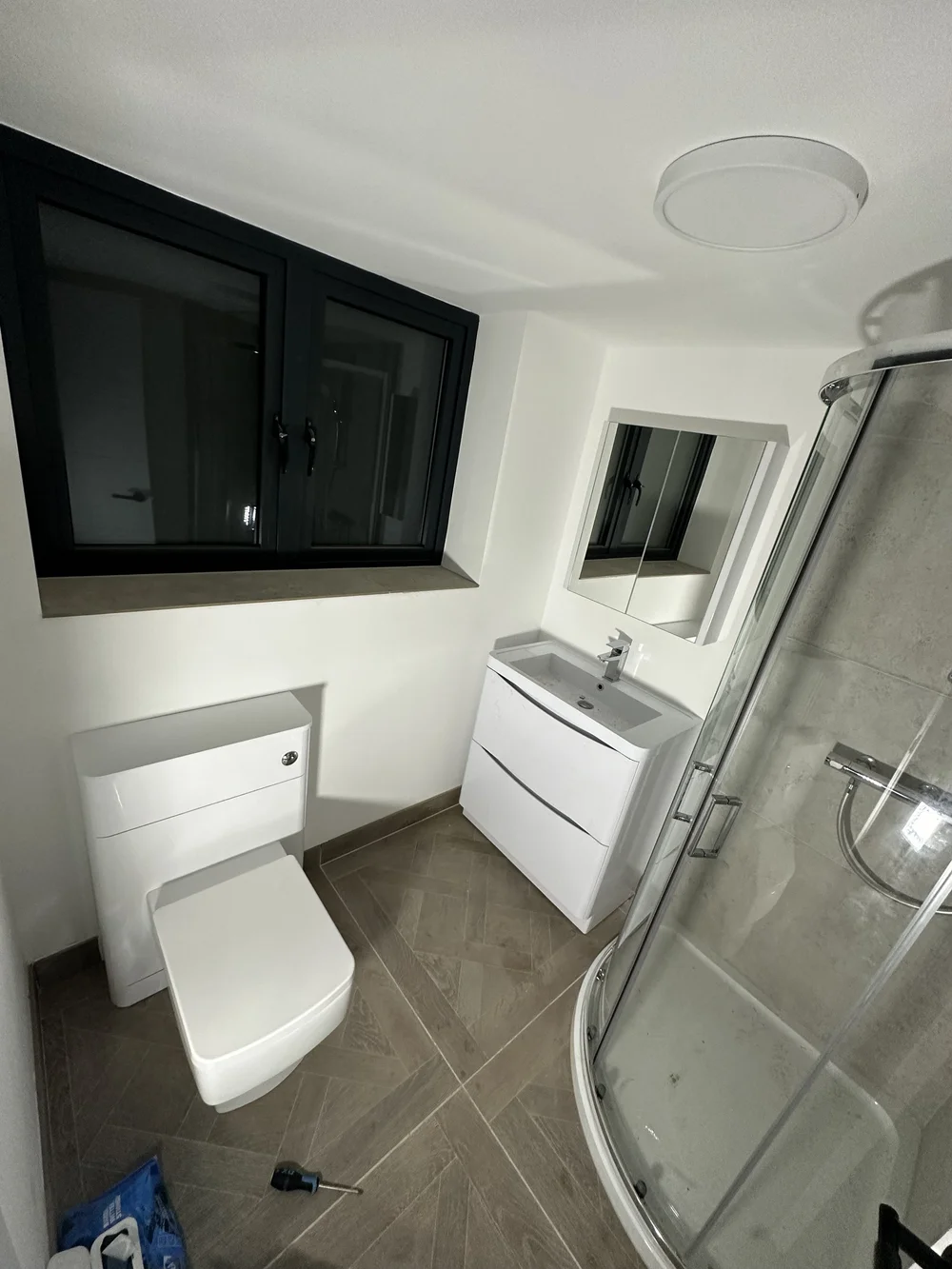 Compact ensuite with quadrant shower enclosure, wall-hung vanity and back-to-wall WC — bathroom installation Basingstoke