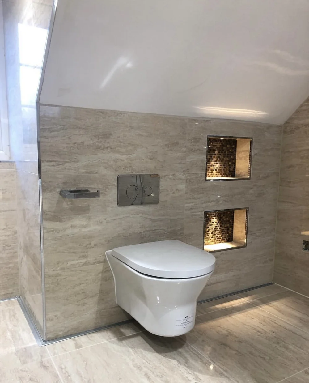 Travertine wet room with wall-hung WC and illuminated mosaic niches — bathroom renovation Basingstoke