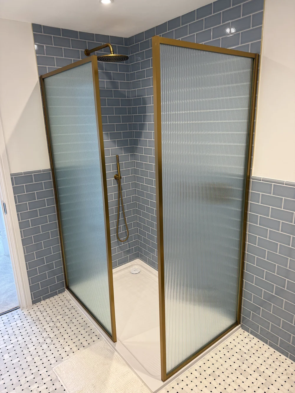 Blue metro tile walk-in shower with brushed brass fluted screens — Basingstoke bathroom fitters