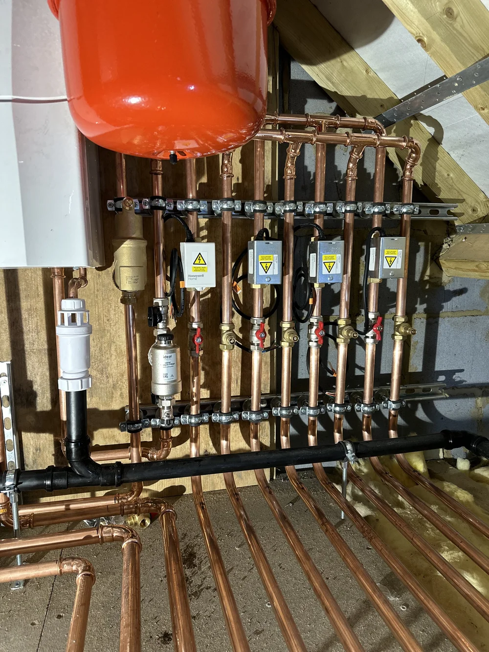 Detailed copper manifold with Honeywell zone controls and Ideal system filter — plumber Basingstoke