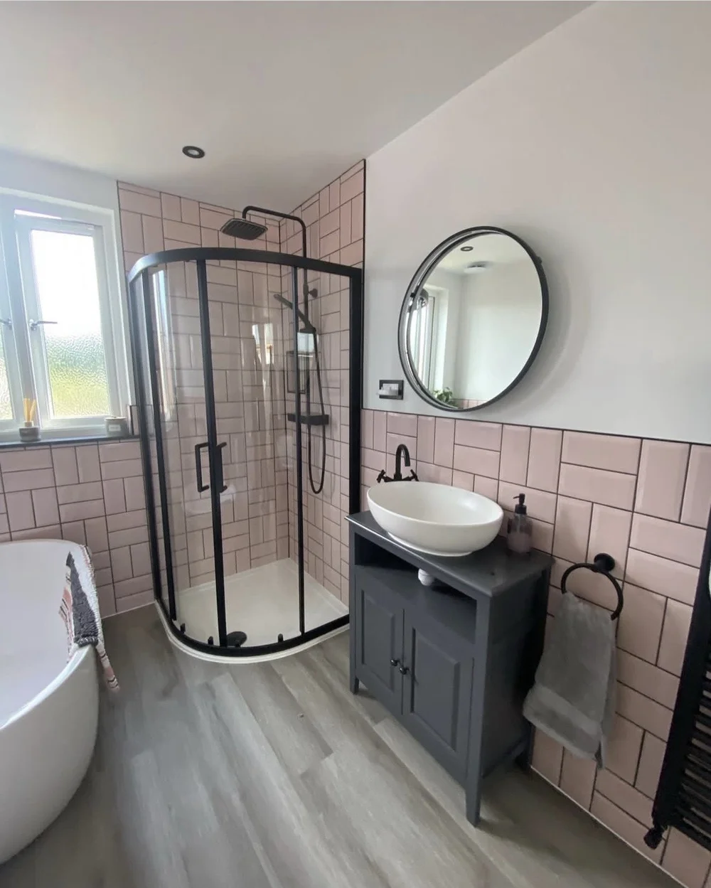 Pink metro-tiled bathroom with black-framed quadrant shower, freestanding bath and vessel basin — bathroom renovation Basingstoke