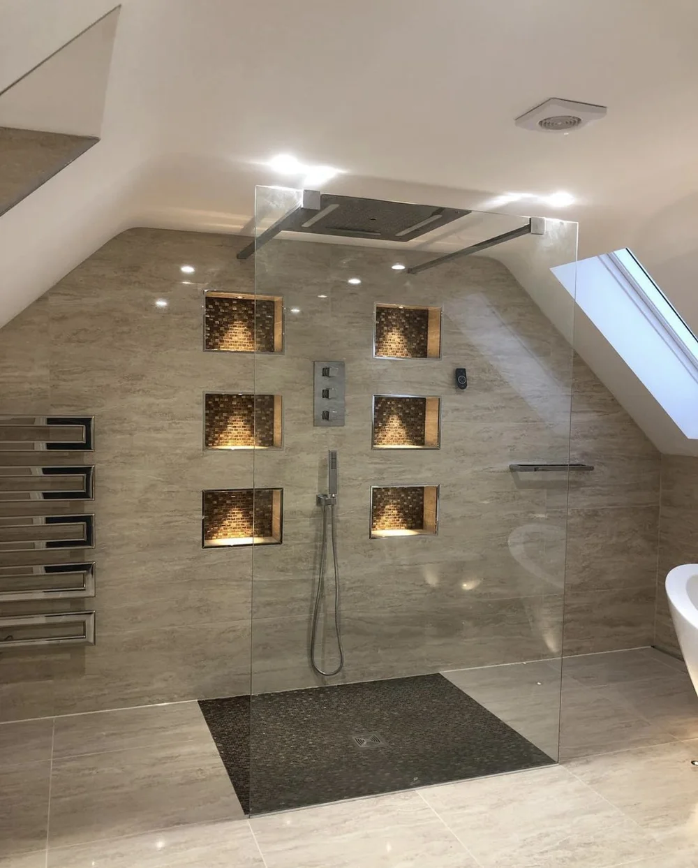 Luxury loft wet room with travertine walls, mosaic niches and frameless glass screen — Basingstoke bathroom fitters