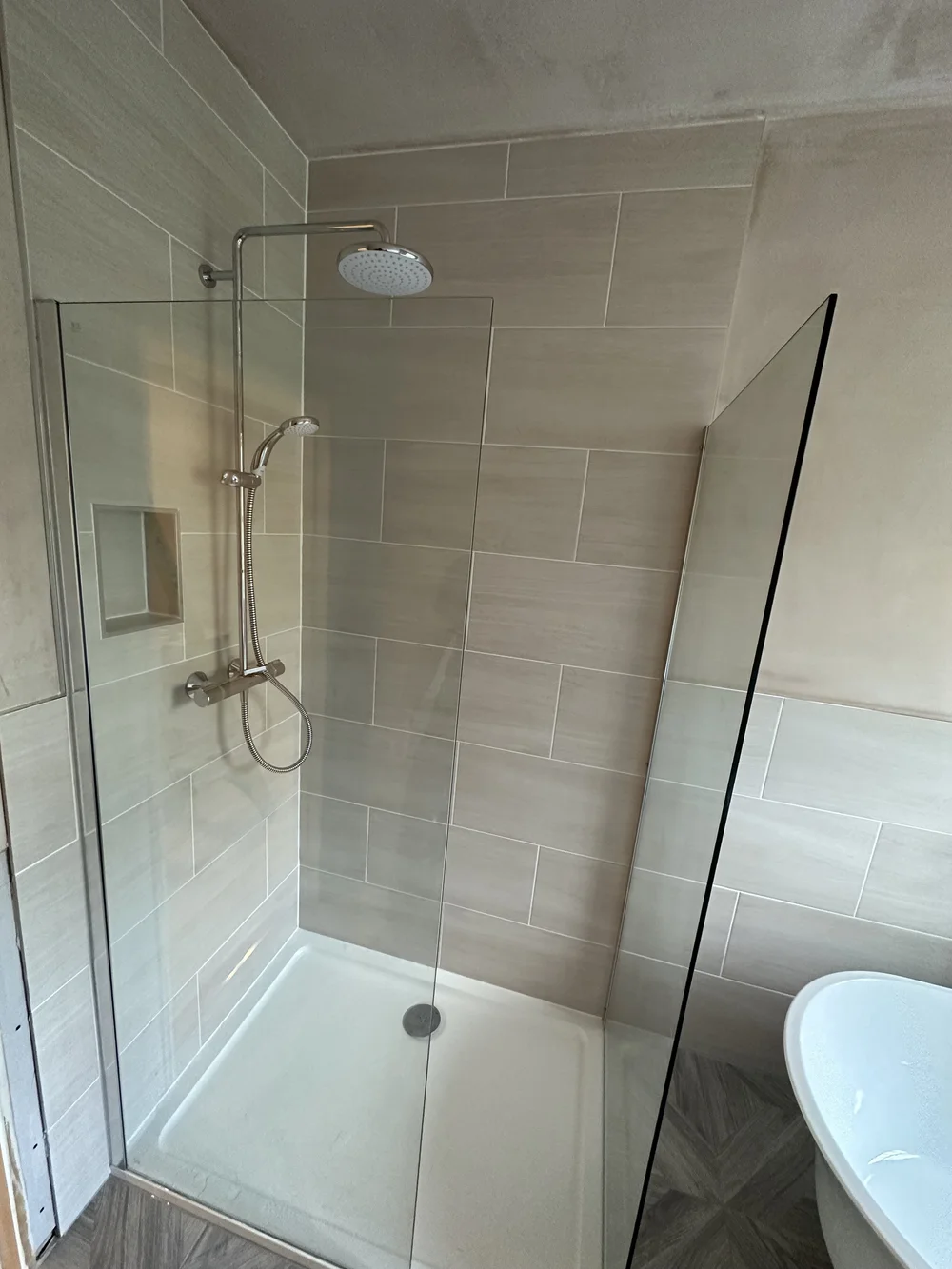 Walk-in shower with cream metro tiles, brushed nickel rainfall column and glass screen — bathroom installation Basingstoke